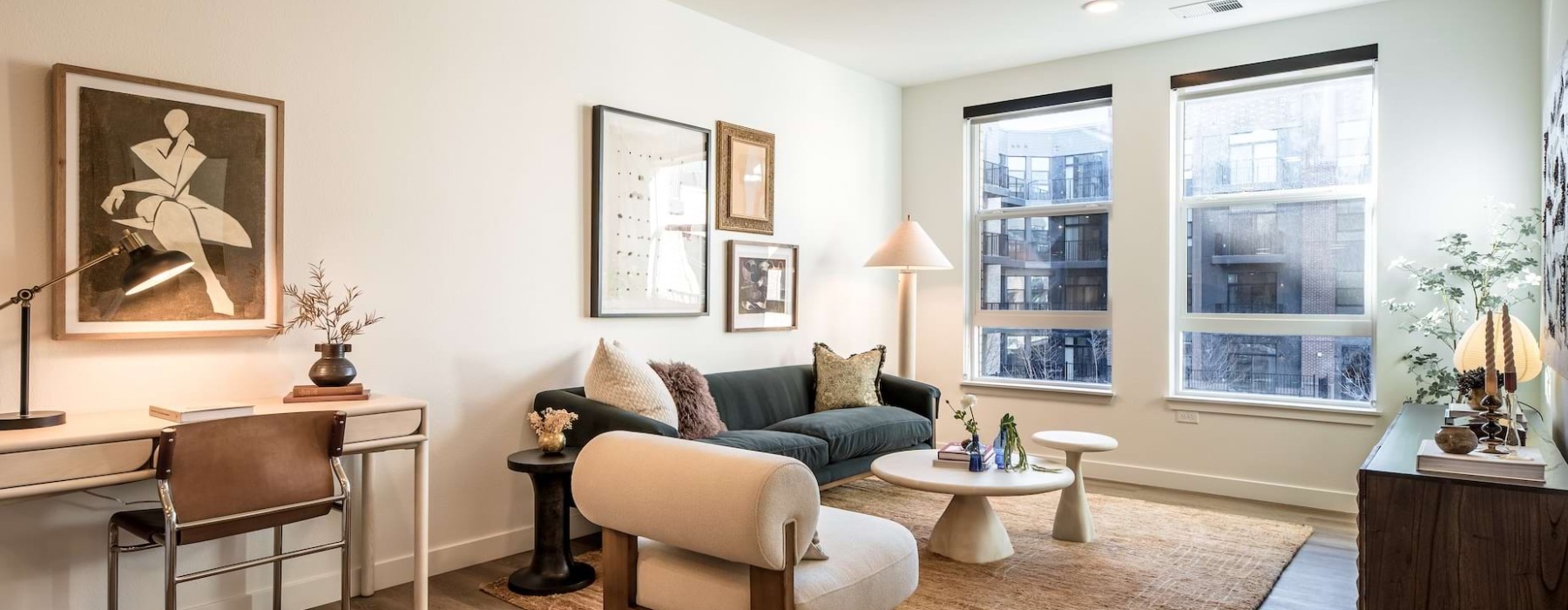 Furnished living room with desk at The Russell apartments in Olde Arvada.	